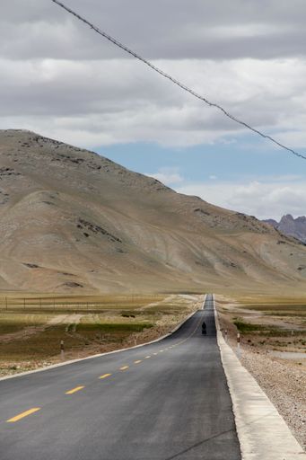 An aerial view of road through desert surrounded by hills