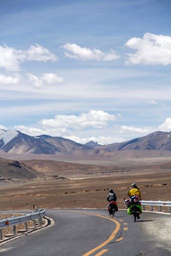 An aerial view of road through desert surrounded by hills