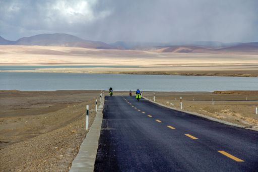 An aerial view of road through desert surrounded by hills