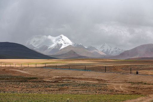 A beautiful landscape with snow cap mountains against the cloudy sky