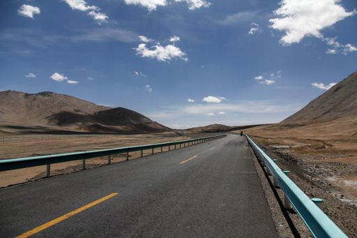 A beautiful shot of a road in a brown landscape under the clouds
