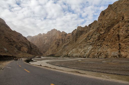 A beautiful shot of a road in a brown landscape under the clouds