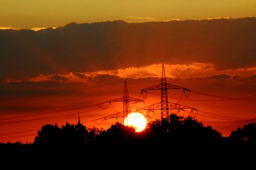 dark silhouette of trees and a sunset on a cloudy sky with interesting light ray