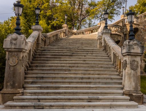A low-angle closeup of a long ancient stone stairway with black decorative lights