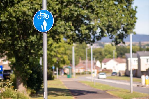 A closeup of a pedestrian and a bike path sign on the streets