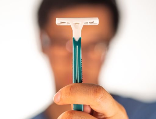 A man holding a sharp plastic shaving razor