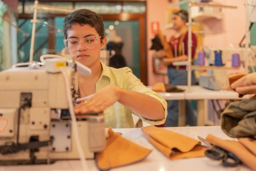 Caucasian young woman working with a sewing machine in a workshop