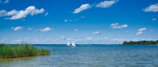 A panorama of the Chiemsee in Bavaria with a lot of small sailing boats