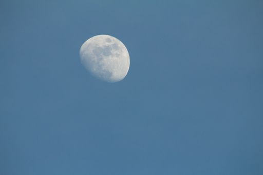 A beautiful shot of the moon - waxing crescent with clear blue sky on the background