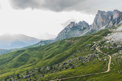 A low angle shot of a rock formation in the middle of a mountainous scenery under the gloomy sky in the Dolomites, Italy