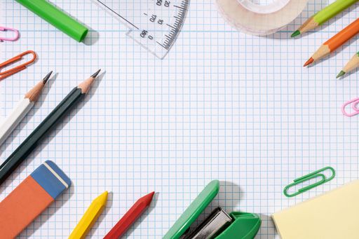 Frame of School and office supplies on blank graph paper sheet. Back to school background. Flat lay template mock up