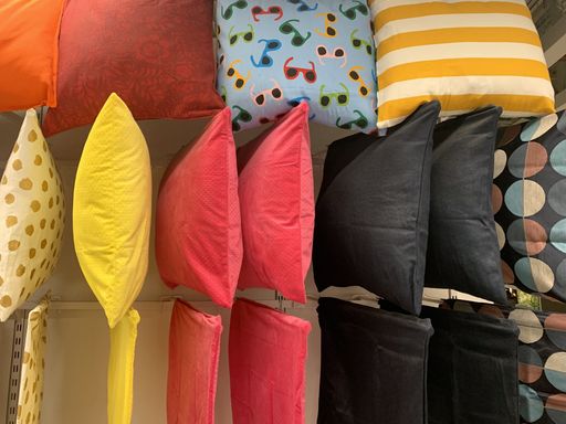A closeup shot of various types of pillows in a shelf in a store