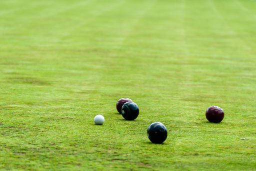 A close-up shot of white 'jack' and near by bowls, Bowling green