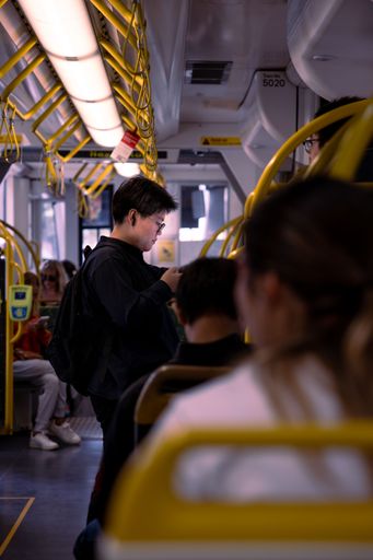 The vertical view of people sitting and standing on the bus