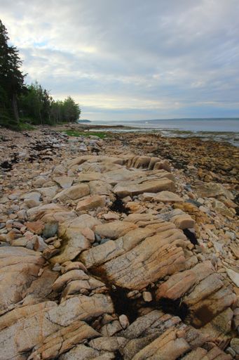 A vertical shot of large stones on a gloomy day at the beach