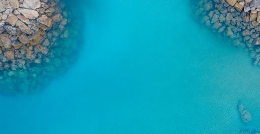 An aerial shot of a crystal clear sea surrounded by rocks under the sunlight in Protaras, Cyprus