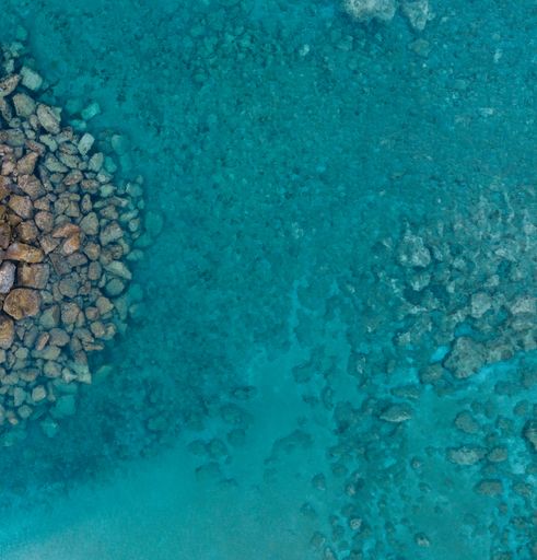 An aerial shot of a crystal clear sea surrounded by rocks under the sunlight in Protaras, Cyprus