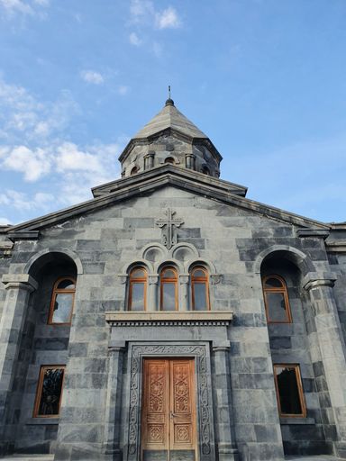 A vertical low angle shot of a historic Christian church and the bright sky in the background