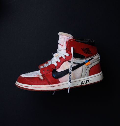 A closeup shot of a worn-out Air Jordan 1 beaten-up sneaker in a dark background