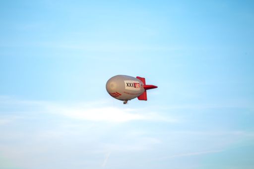 A closeup shot of the XXXLutz airship flying over Niederlenz, Switzerland against the clear sky