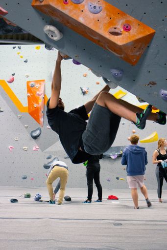 A vertical shot of a male climber on climbing wall