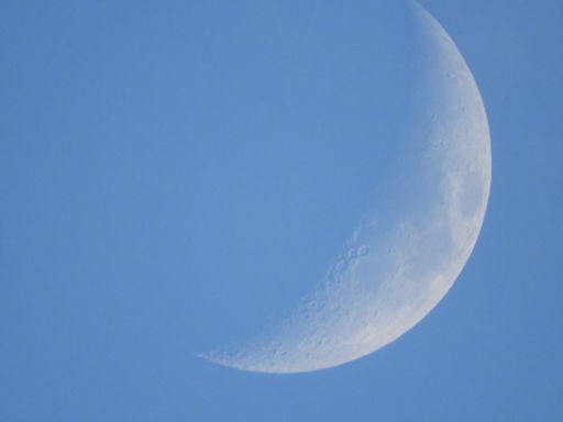A beautiful view of a quarter moon in a blue and clear sky