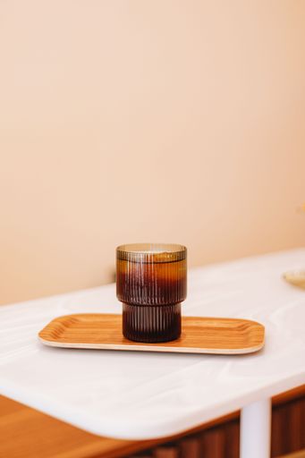 A vertical shot of a cold brew tonic drink in a glass cup.