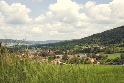A high angle shot of the village houses in the valley surrounded by hills on a cloudy day