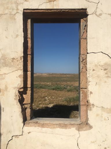 A photo of the landscape from the window of an abandoned building