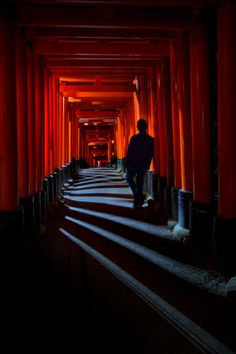 A person standing in the Fushimi Inari Taisha Shrine in Kyoto, Japan