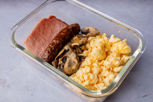 A closeup shot of omelette with bacon and mushrooms in a glass bowl