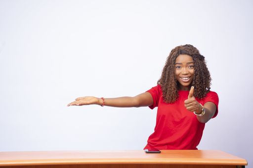 A pretty black female pointing to the space on her side and giving a thumbs up - 
advertising concept