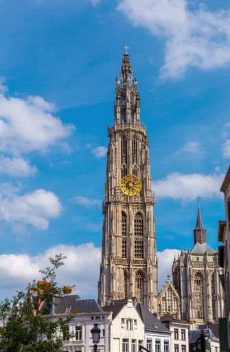 A vertical shot of the Cathedral of Our Lady of Antwerp against a blue sky on a sunny day in Belgium