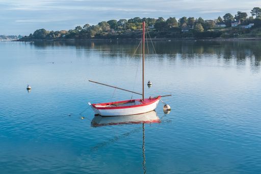 Brittany, Ile aux Moines island in the Morbihan gulf, beautiful landscape after the rain, with turquoise sea, and a red boat
