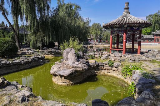A Chinese pavilion beside a pond at a public park in Beijing, China