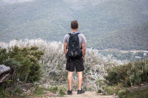 A caucasian man admiring the beautiful scenery of mountains during his hike