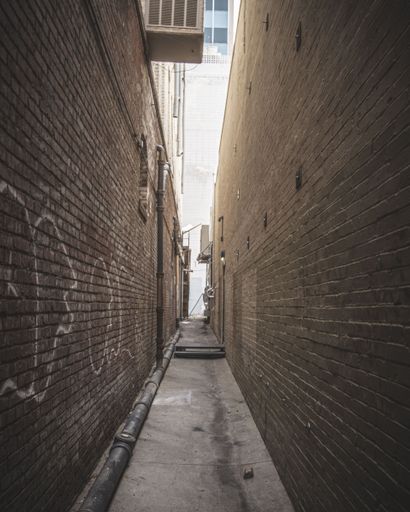 A narrow alley between stone brick walls in El Paso, Texas, vertical shot