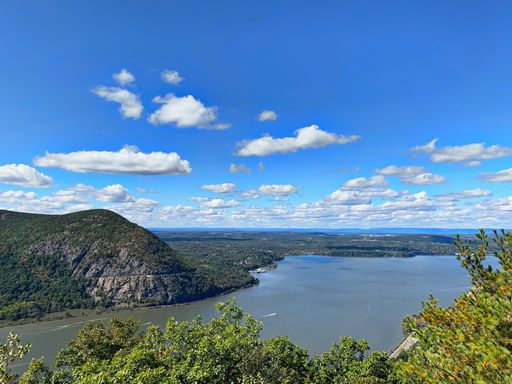A scenic view of Breakneck Ridge along the Hudson River on a sunny day, New York