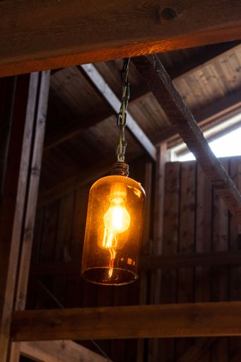 A vertical closeup shot of a ceiling lamp hanging from the wooden body