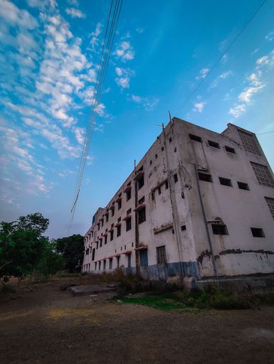 A vertical shot of an old abandoned stone building against the blue sunny sky