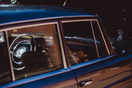 A closeup shot of a Mercedes Benz 220s from 60's with its logo, vintage photography