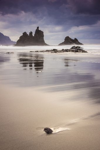 A vertical shot of Benijo beach in the island of Tenerife, Spain with rock formations in the horizon