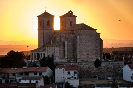 A scenic view of a building against the sun during sunset
