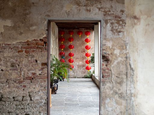 The blur concrete entrance as foregound, Chinese lantern hanging on the wall.