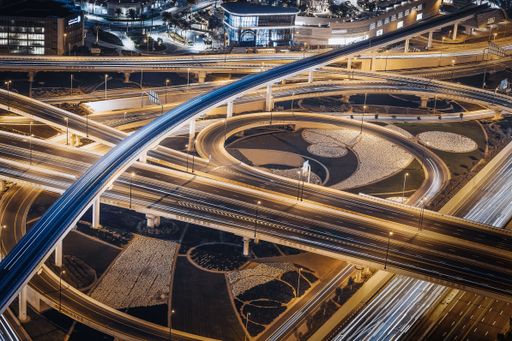 The aerial view of illuminated Dubai highway empty roads at night