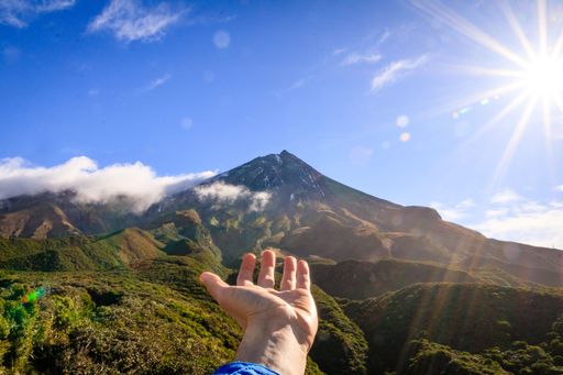 A person pointing at the Mount Taranaki, Taranaki, New Zealand