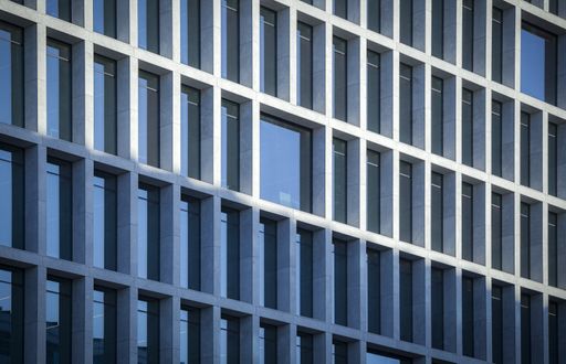 A closeup shot of the windows on a building reflecting the sky