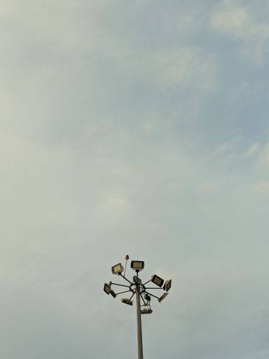 A stadium light pole against the gloomy sky