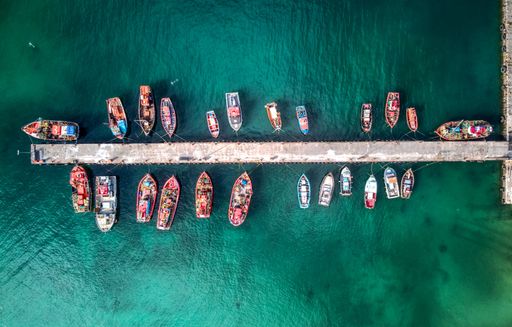 A aerial drone shot of many fishing boats in Kalk Bay harbour, near Cape Town, South Africa