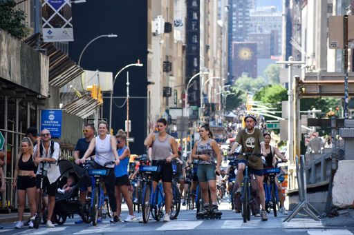 A New York street view with people walking and biking around during a car-free Summer Streets event along Park Avenue